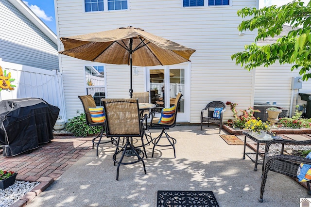 view of patio with grilling area, fence, central AC, and outdoor dining space