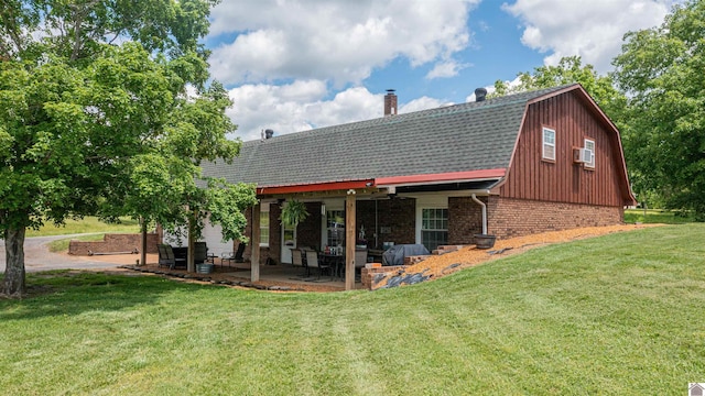 2782 Foust Sledd Rd, Benton, KY 42025 - back of property with a gambrel roof, brick siding, a lawn, a shingled roof, and a chimney
