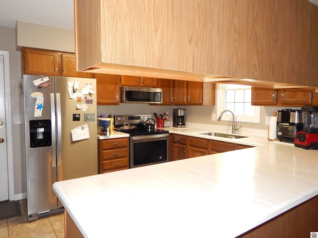 222 Ash St, Benton, KY 42025 - kitchen featuring appliances with stainless steel finishes, a sink, brown cabinets, light countertops, and a peninsula