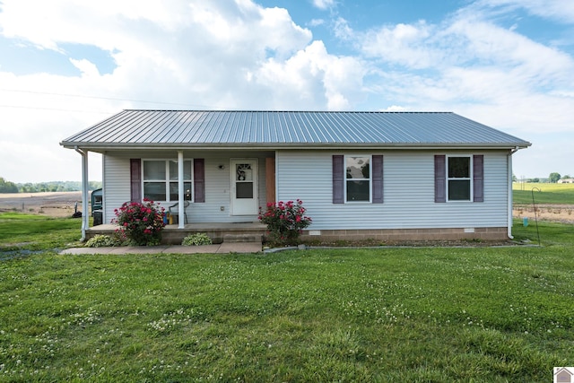 single story home with covered porch, metal roof, and a front yard
