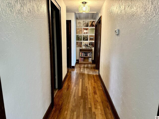203 N 17th, Murray, KY 42071 - corridor with attic access, a textured wall, wood finished floors, baseboards, and built in shelves