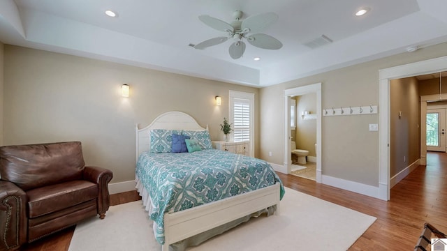 171 Cagel, Gilbertsville, KY 42044 - bedroom with a tray ceiling, wood finished floors, baseboards, recessed lighting, and connected bathroom