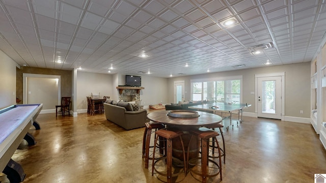 171 Cagel, Gilbertsville, KY 42044 - dining room featuring concrete floors, a stone fireplace, and baseboards