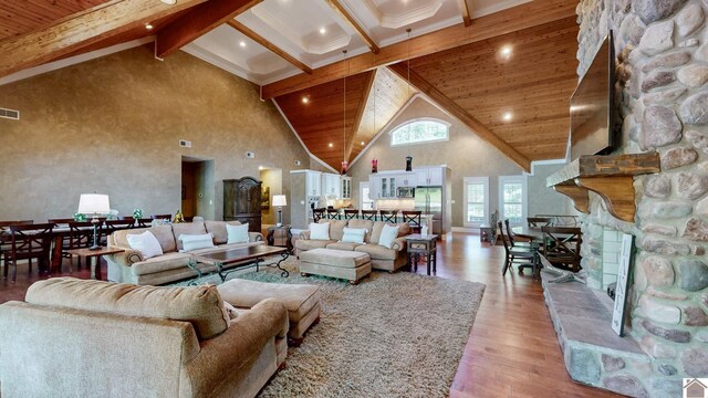 171 Cagel, Gilbertsville, KY 42044 - living room with high vaulted ceiling, light wood-style floors, beamed ceiling, a stone fireplace, and wooden ceiling
