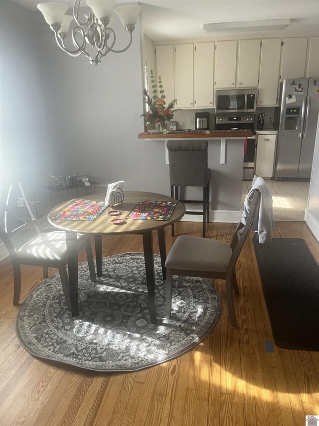 dining room with a chandelier and light wood-style flooring