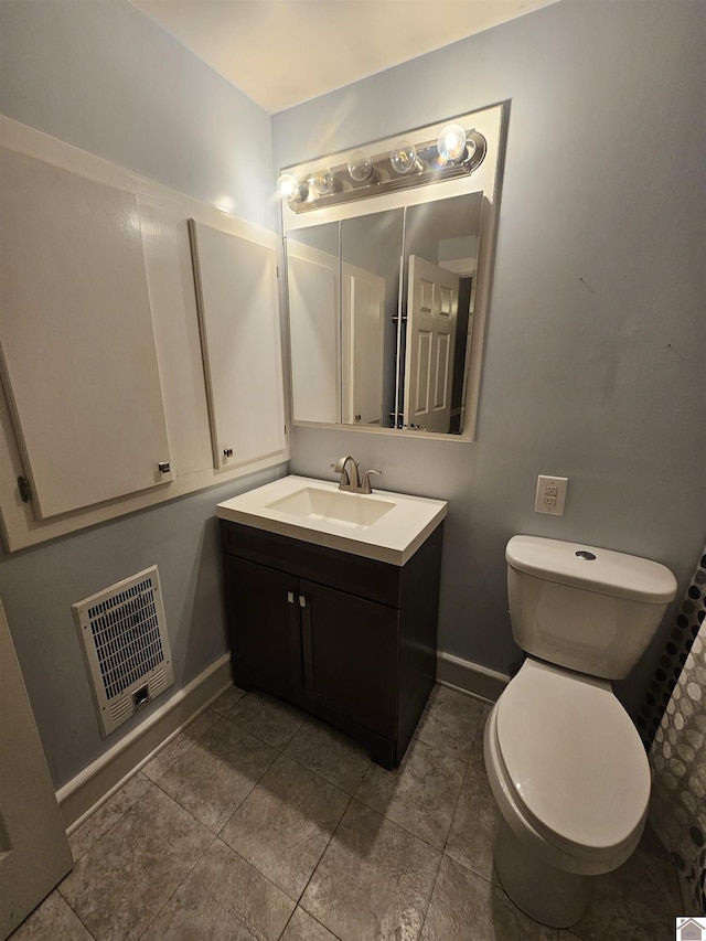 bathroom featuring toilet, vanity, and baseboards
