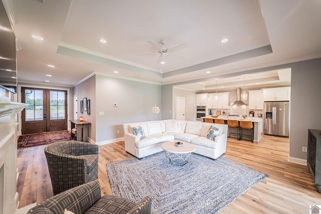 112 Shadow Pine Ln, Paducah, KY 42001 - living room with a tray ceiling, light wood finished floors, baseboards, crown molding, and a ceiling fan