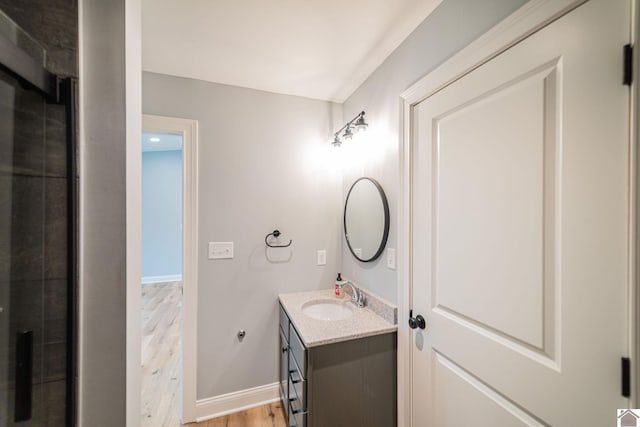 112 Shadow Pine Ln, Paducah, KY 42001 - bathroom featuring vanity, wood finished floors, baseboards, and a tile shower