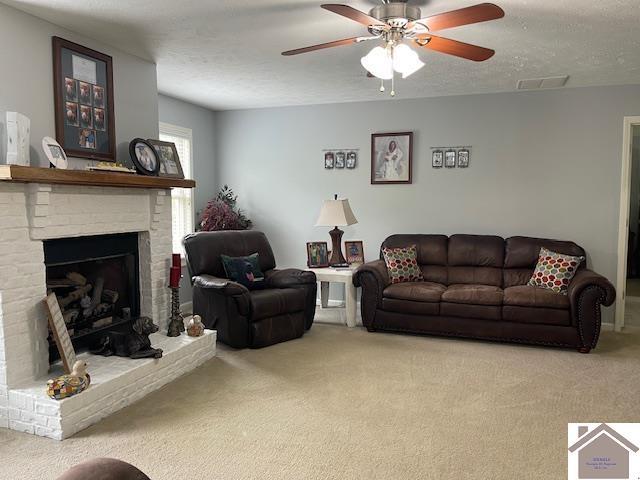 695 Heritage Trce, Cadiz, KY 42211 - living room with carpet flooring, a ceiling fan, a textured ceiling, and a fireplace