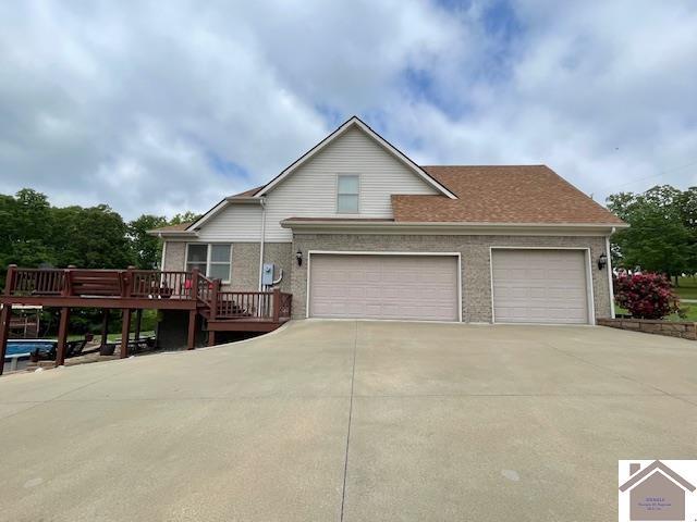 695 Heritage Trce, Cadiz, KY 42211 - view of front of house featuring concrete driveway, an attached garage, a deck, and brick siding