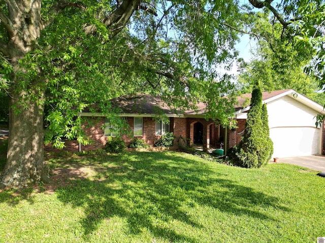 ranch-style home with brick siding, a front yard, and concrete driveway