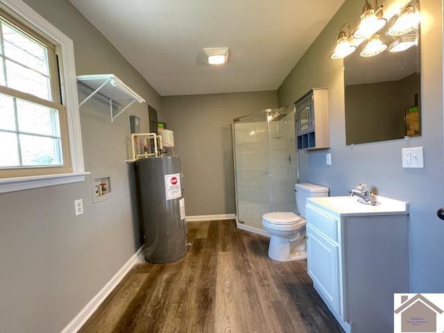197 Briarfield Ln, Cadiz, KY 42211 - bathroom featuring electric water heater, wood finished floors, a stall shower, toilet, and vanity