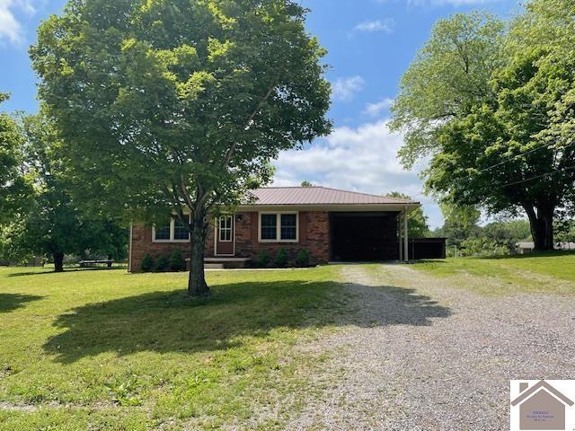 197 Briarfield Ln, Cadiz, KY 42211 - ranch-style house featuring gravel driveway, an attached garage, a front yard, and metal roof