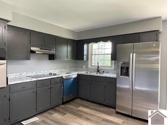 197 Briarfield Ln, Cadiz, KY 42211 - kitchen with stainless steel fridge, black electric cooktop, dishwashing machine, wood finished floors, and under cabinet range hood