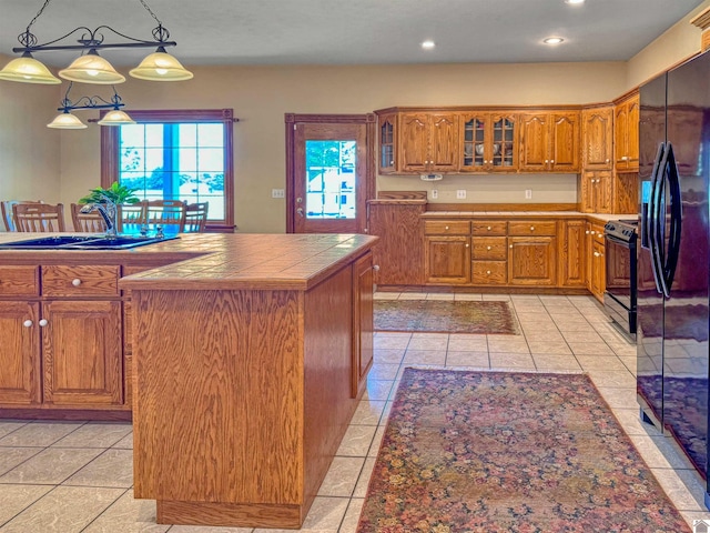 730 Rob Mason Rd, Murray, KY 42071 - kitchen featuring tile countertops, black appliances, brown cabinetry, glass insert cabinets, and light tile patterned floors