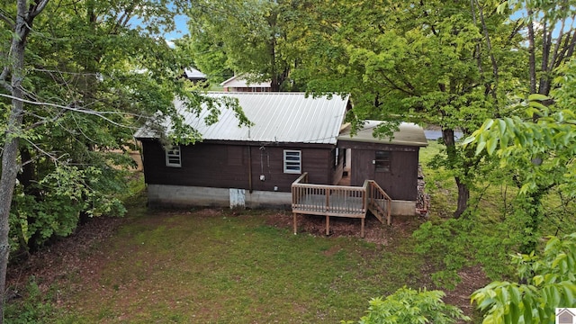 back of house featuring a deck and metal roof
