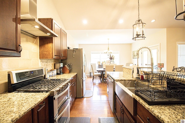 1300 Rocky Rd, Fancy Farm, KY 42039 - kitchen featuring stainless steel appliances, wall chimney exhaust hood, a chandelier, wood finished floors, and tasteful backsplash
