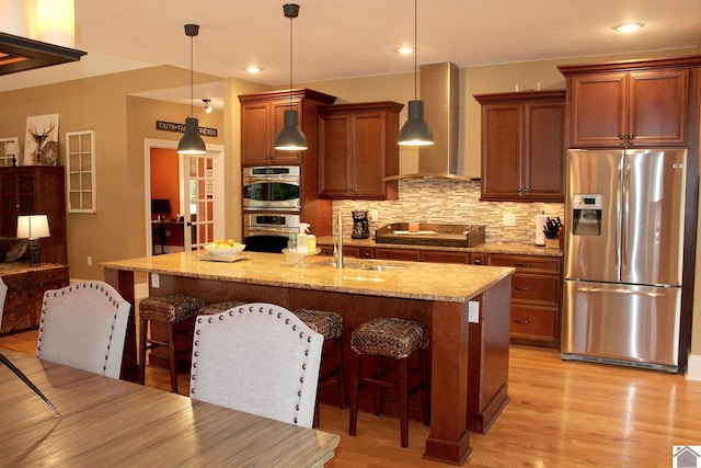 494 Beat Farmer Rd, New Concord, KY 42076 - kitchen with stainless steel appliances, wall chimney exhaust hood, a sink, a breakfast bar area, and tasteful backsplash