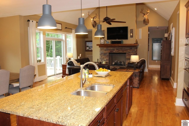 494 Beat Farmer Rd, New Concord, KY 42076 - kitchen featuring a sink, open floor plan, vaulted ceiling, light wood-style floors, and a fireplace