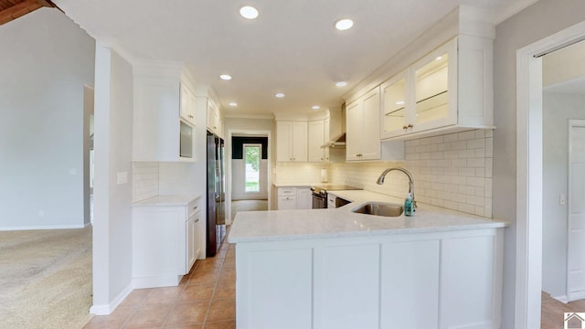 kitchen featuring a sink, appliances with stainless steel finishes, recessed lighting, white cabinets, and a peninsula