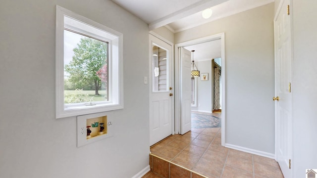 hall featuring light tile patterned floors, baseboards, and crown molding