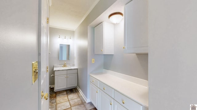bathroom with crown molding, vanity, stone finish floors, and baseboards