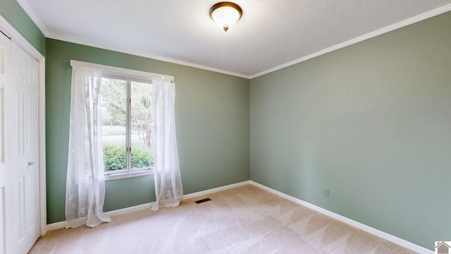 empty room featuring plenty of natural light, baseboards, carpet flooring, and ornamental molding