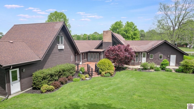 view of front of house with a chimney, a front lawn, and roof with shingles