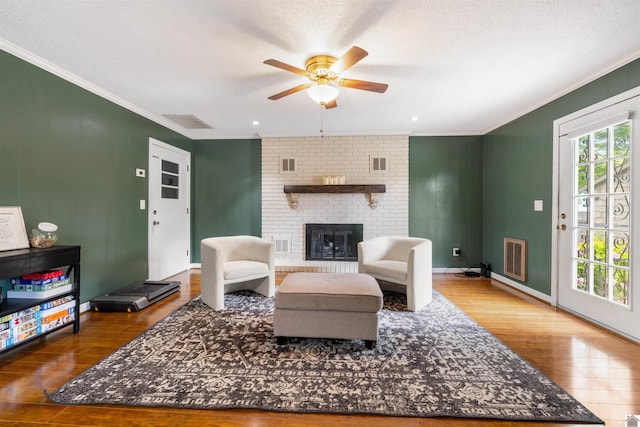 521 Whitnell Ave, Murray, KY 42071 - living room featuring crown molding, wood finished floors, ceiling fan, a fireplace, and baseboards