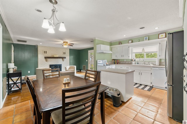 521 Whitnell Ave, Murray, KY 42071 - dining room featuring a brick fireplace, ceiling fan, crown molding, a textured ceiling, and recessed lighting