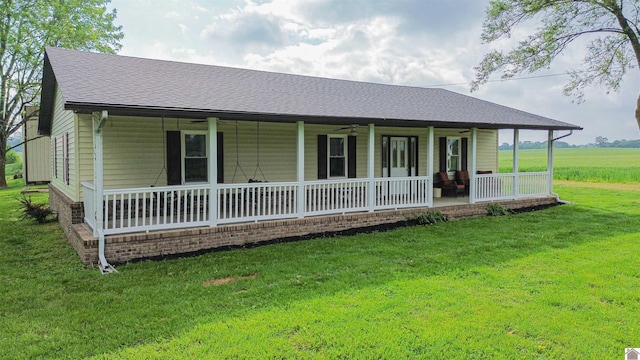 view of front facade with roof with shingles, a front yard, and a porch