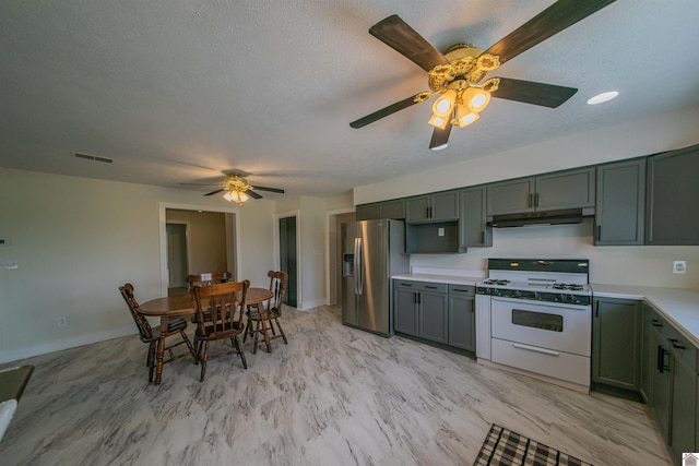 kitchen featuring white range with gas stovetop, stainless steel fridge with ice dispenser, under cabinet range hood, ceiling fan, and light countertops