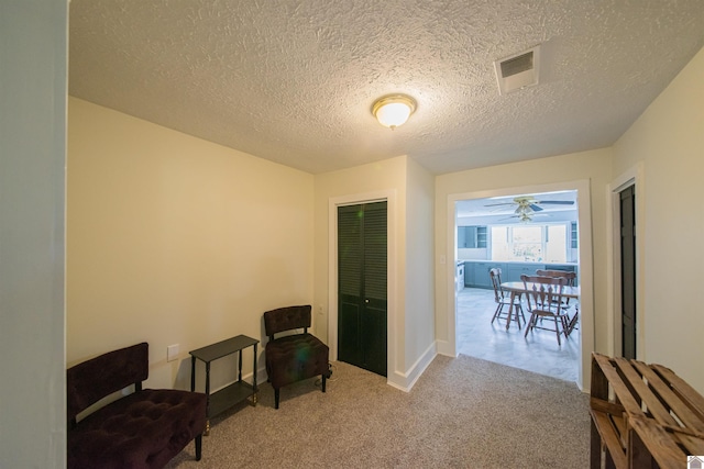 sitting room featuring carpet floors, a textured ceiling, ceiling fan, and baseboards