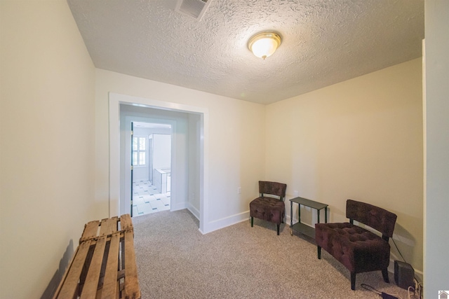 unfurnished room featuring carpet, a textured ceiling, and baseboards