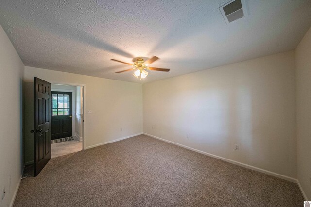 unfurnished room featuring light carpet, a ceiling fan, baseboards, and a textured ceiling
