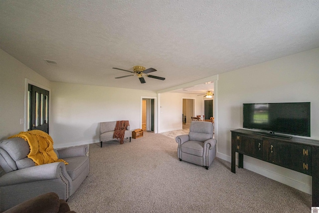 living room featuring ceiling fan, carpet flooring, a textured ceiling, and baseboards