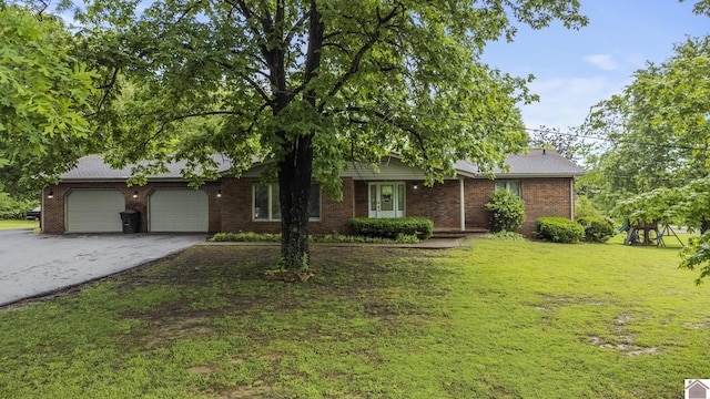 890 Ridge Rd, Gilbertsville, KY 42044 - view of front of house with asphalt driveway, a garage, a front lawn, and brick siding