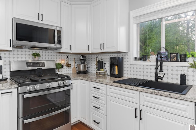 890 Ridge Rd, Gilbertsville, KY 42044 - kitchen featuring appliances with stainless steel finishes, a sink, white cabinetry, and backsplash