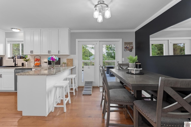 890 Ridge Rd, Gilbertsville, KY 42044 - kitchen featuring a sink, stainless steel dishwasher, light wood-type flooring, ornamental molding, and decorative backsplash