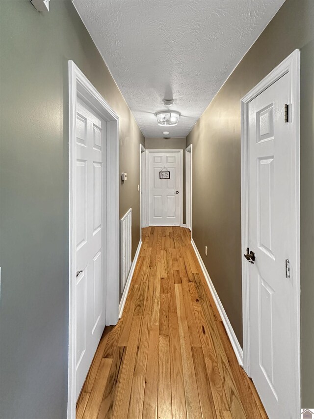 478 Lovers Ln, Benton, KY 42025 - hall with a textured ceiling, light wood-style flooring, and baseboards