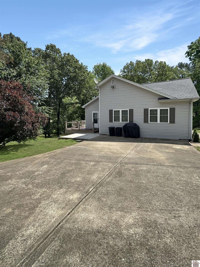 478 Lovers Ln, Benton, KY 42025 - back of property with concrete driveway, roof with shingles, and view of wooded area