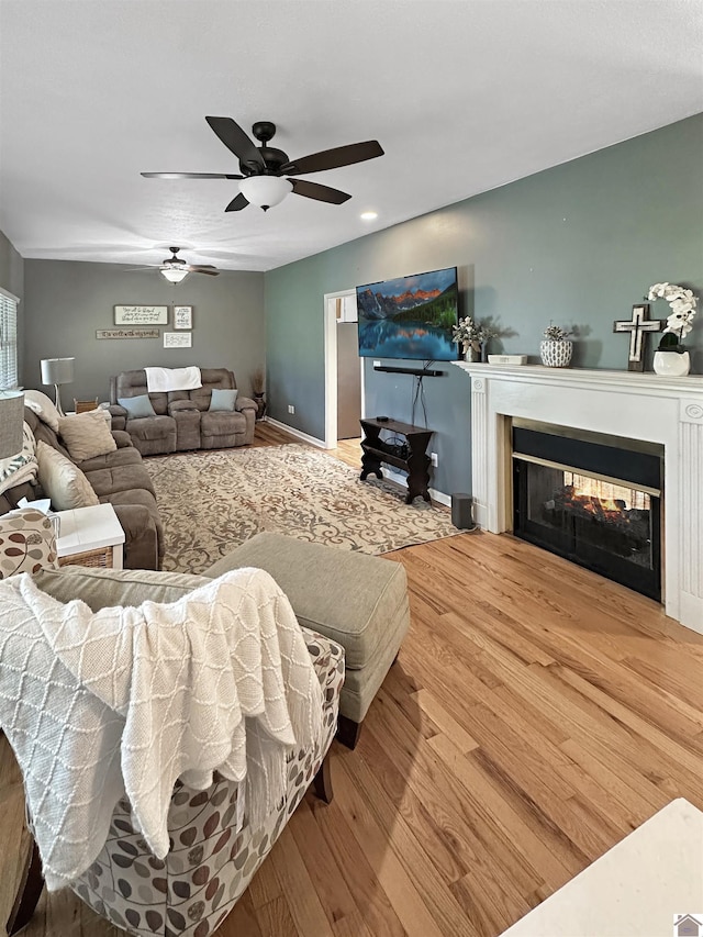 478 Lovers Ln, Benton, KY 42025 - living room featuring a ceiling fan, a multi sided fireplace, wood finished floors, and baseboards