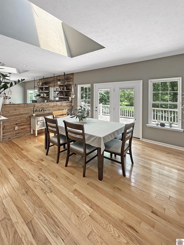 478 Lovers Ln, Benton, KY 42025 - dining space with light wood-type flooring, plenty of natural light, a textured ceiling, vaulted ceiling, and a skylight