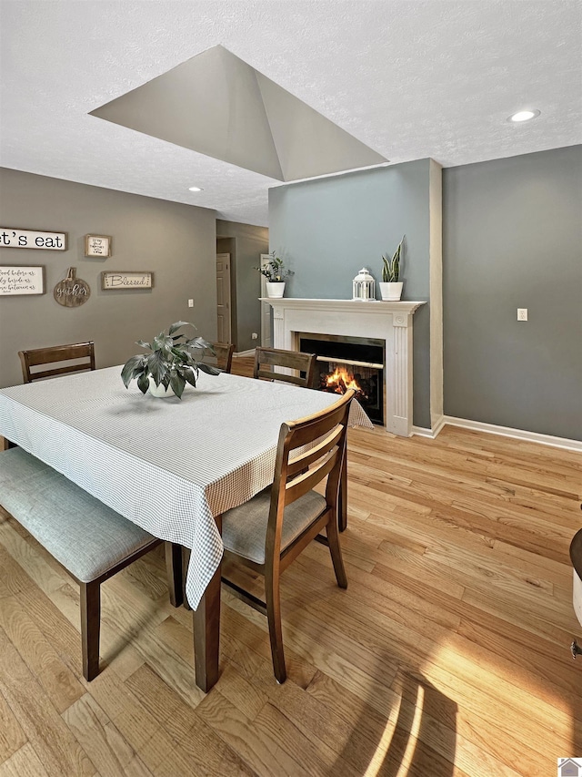 478 Lovers Ln, Benton, KY 42025 - dining area with a glass covered fireplace, light wood finished floors, baseboards, recessed lighting, and a textured ceiling