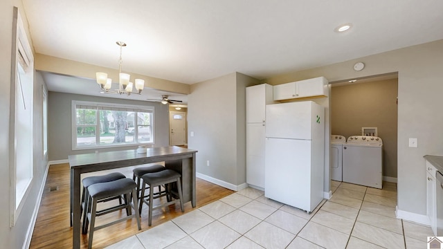 509 S 6th St, Murray, KY 42071 - kitchen with freestanding refrigerator, washer and clothes dryer, a chandelier, white cabinets, and baseboards