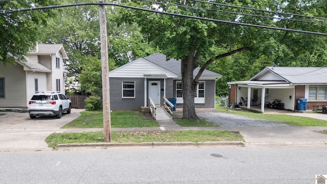 509 S 6th St, Murray, KY 42071 - view of front of property featuring concrete driveway, fence, brick siding, and view of wooded area