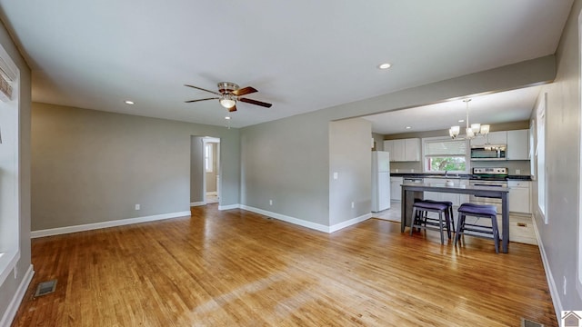509 S 6th St, Murray, KY 42071 - unfurnished living room with light wood-style floors, a ceiling fan, a chandelier, baseboards, and recessed lighting