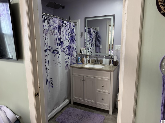 bathroom featuring vanity, a shower with shower curtain, toilet, and wood finished floors
