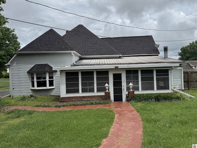 view of front facade featuring roof with shingles and a sunroom