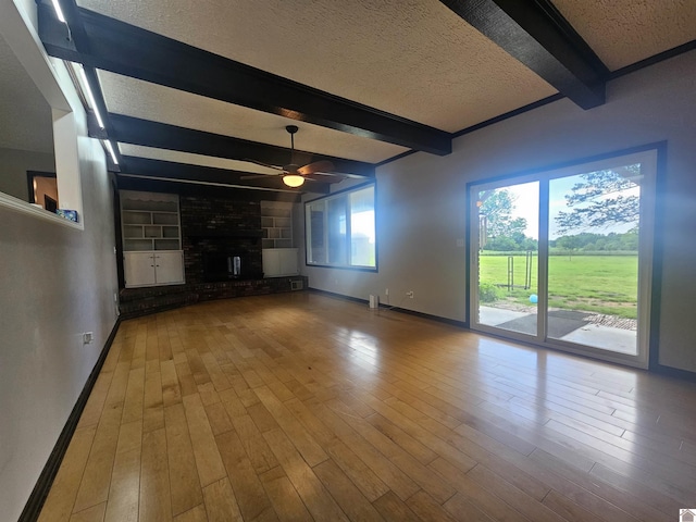 5182 State Route 58 E, Clinton, KY 42031 - unfurnished living room with baseboards, beam ceiling, a textured ceiling, a ceiling fan, and wood finished floors